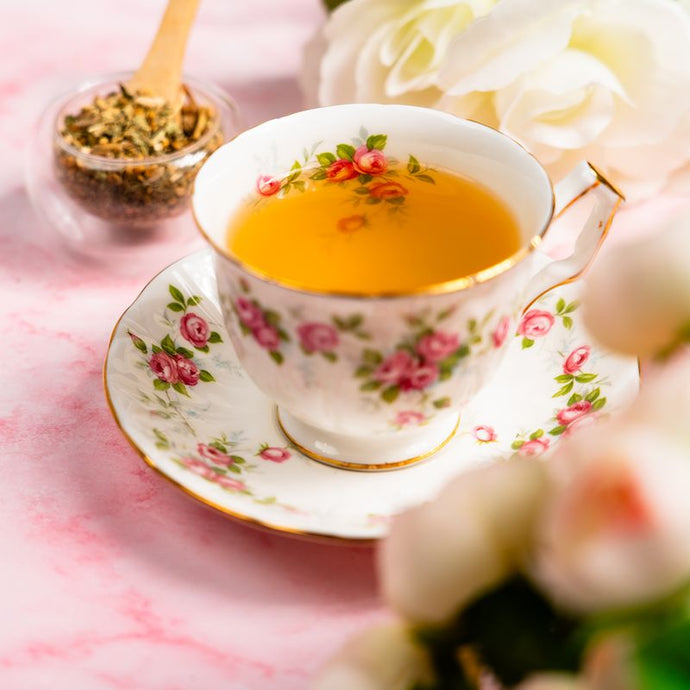 Floral teacup with tea on a pink surface