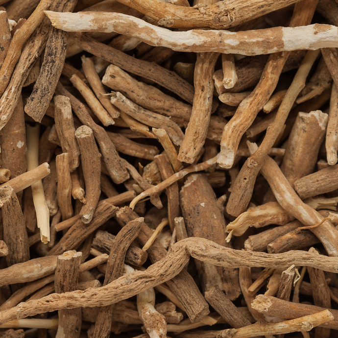 Close-up of dried ashwagandha root pieces showing their natural beige and tan texture.