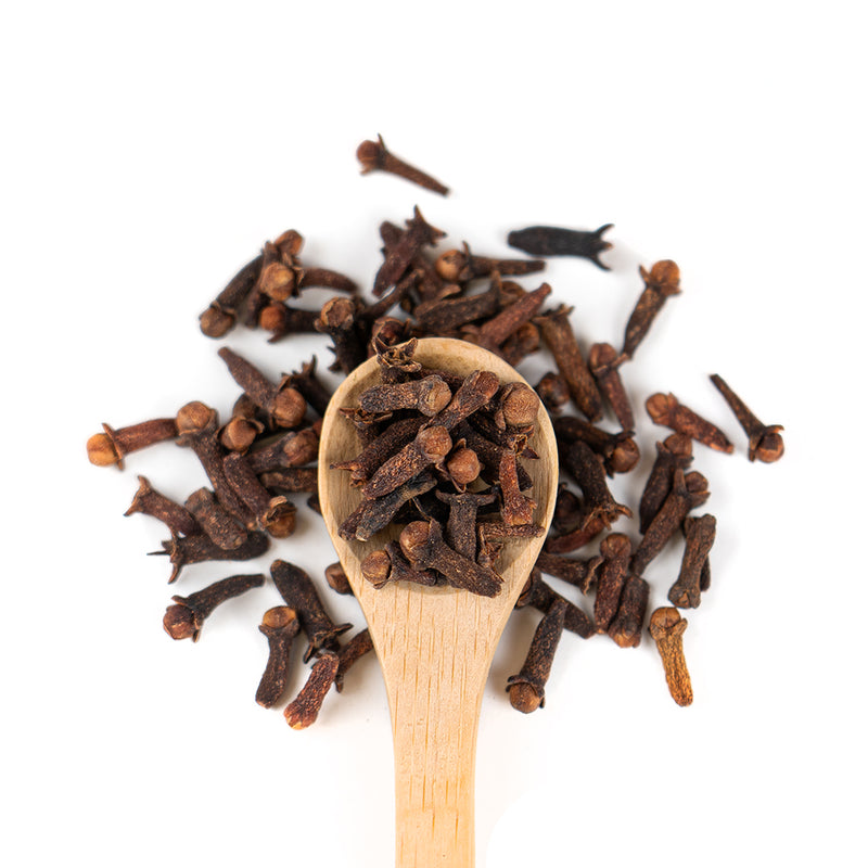 Wooden spoon of Organic Cloves on a white background.