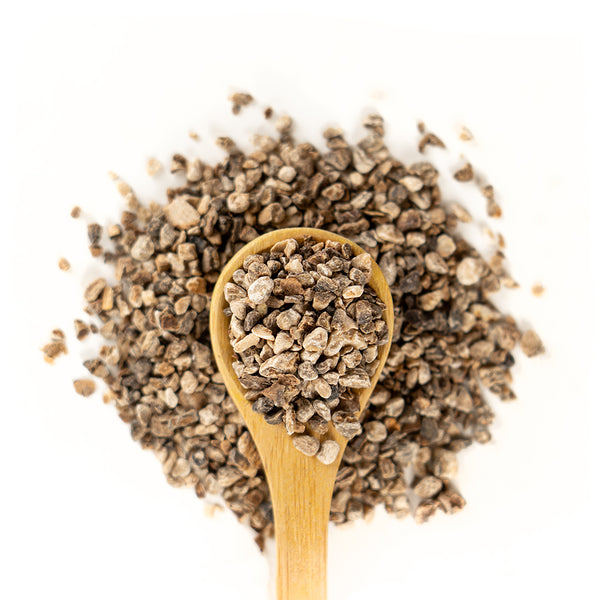 Wooden spoon of Organic Devil's Claw on a white background.