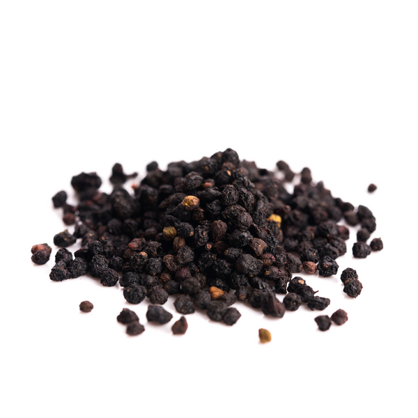 Pile of dried elderberries on a white background.