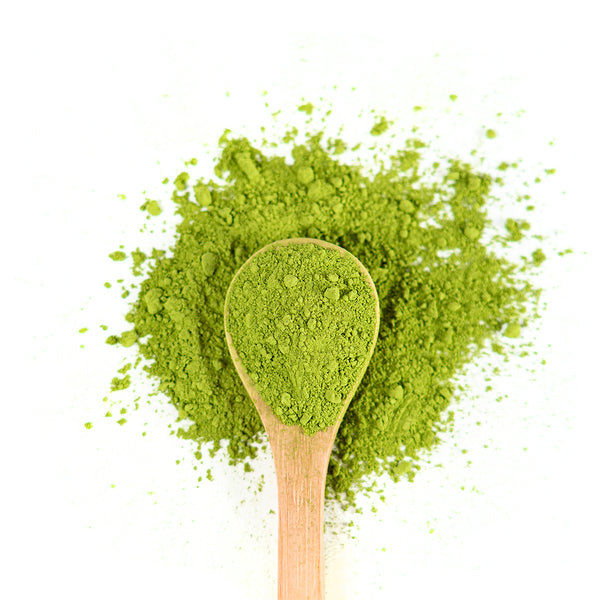 Wooden spoon of Organic Matcha on a white background.
