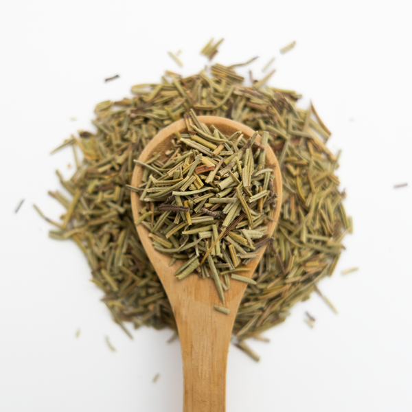 Rosemary overflowing from a wooden spoon on a white background