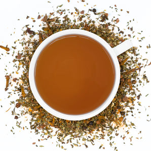 A white cup of Organic Antioxidant Boost Tea surrounded by the loose leaf blend.